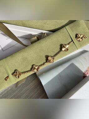 Van Cleef & Arpels Gold Alhambra Motif Bracelet on Olive Green Display